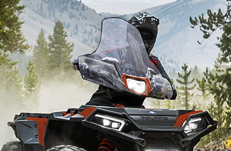 A Polaris Sportsman XP 1000 Ultimate ATV with windshield accessory installed.