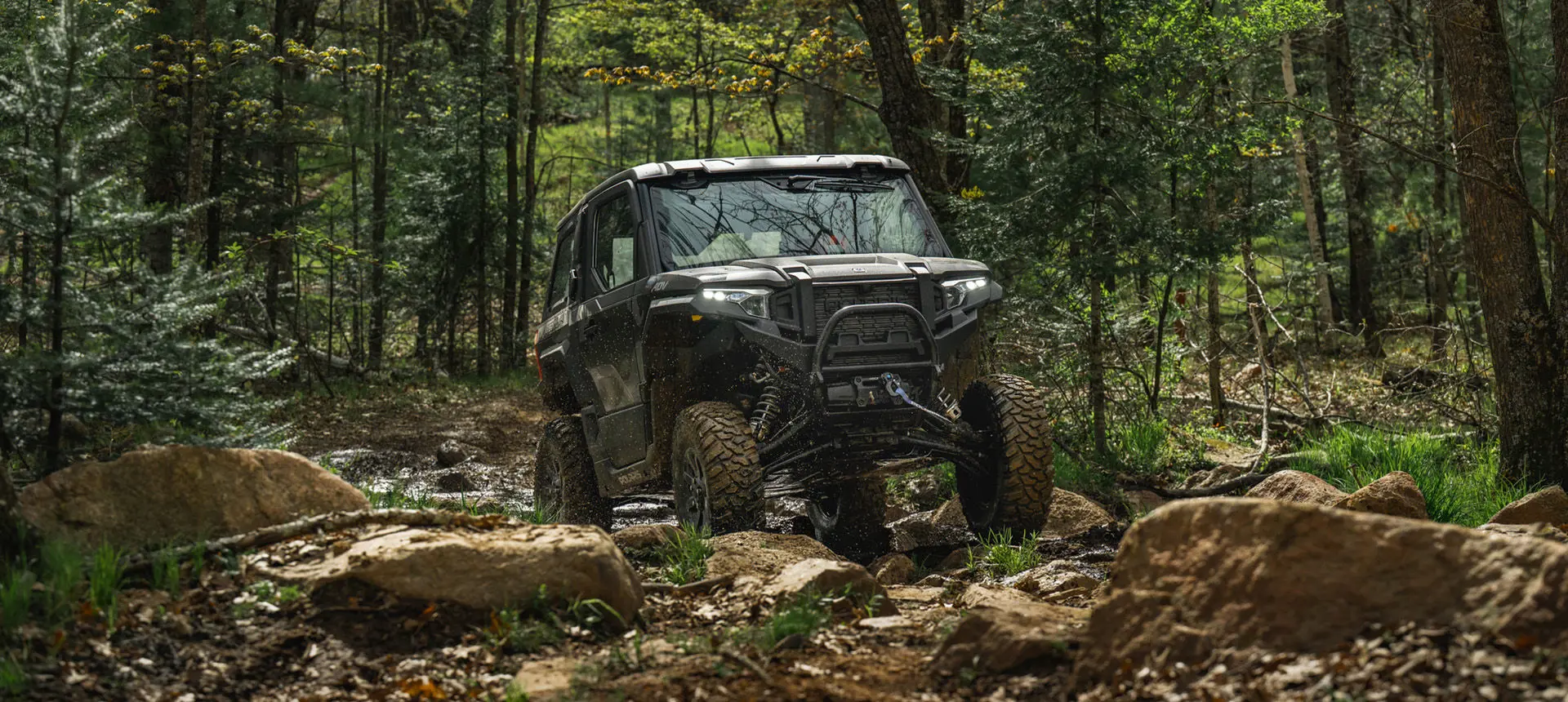 A Matte Super Graphite Polaris XPEDITION ADV NorthStar parked on a hill.