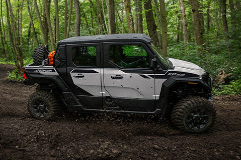 Green Polaris XPEDITION XP with roof rack navigating rocky terrain.