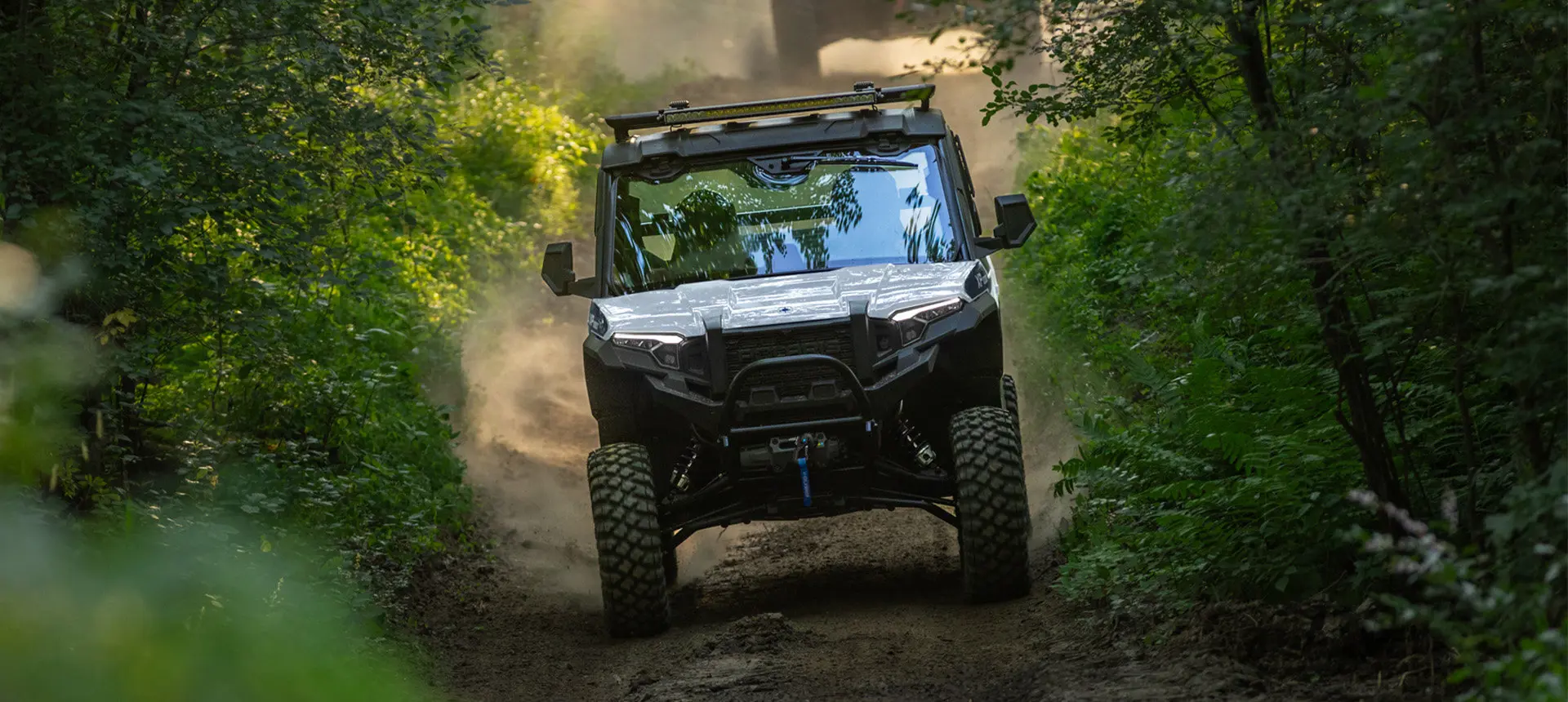 A Polaris XPEDITION XP NorthStar side-by-side trail riding in the forest.