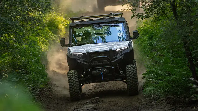 A Polaris XPEDITION XP NorthStar side-by-side trail riding in the forest.