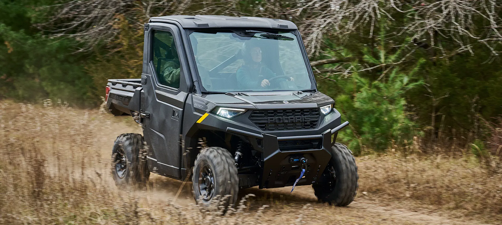 2 riders in a Polaris RANGER 1000 CAB UTV.