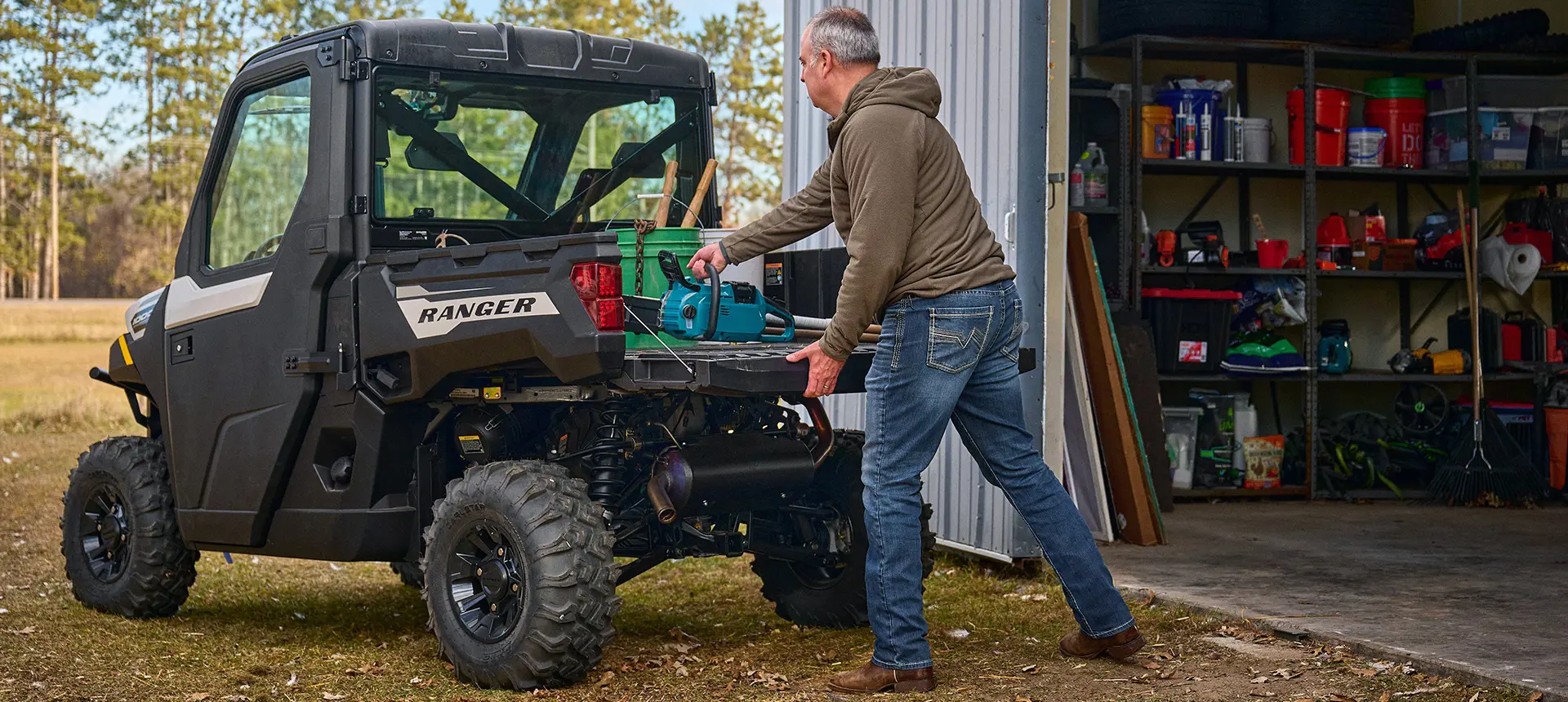 2 riders cruising in a Polaris RANGER 1000 CAB enclosed UTV.