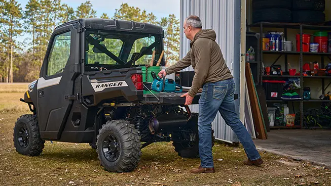 2 riders cruising in a Polaris RANGER 1000 CAB enclosed UTV.