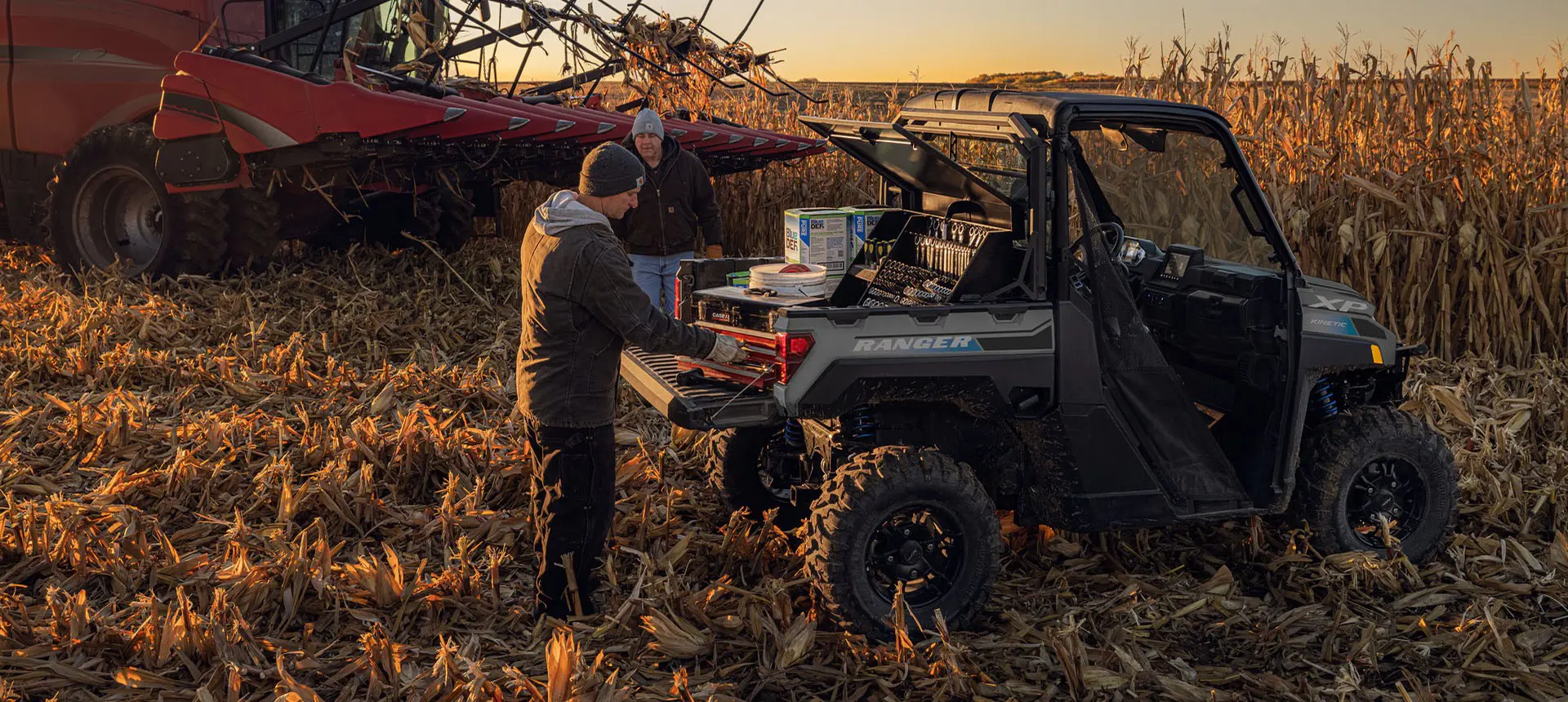 2 farmers grabbing gear from the cargo box of a Polaris RANGER XP Kinetic electric UTV.