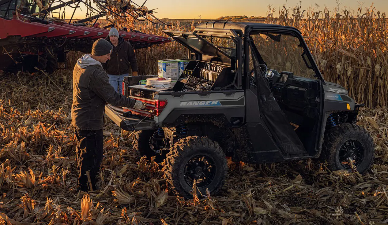 2 farmers grabbing gear from the cargo box of a Polaris RANGER XP Kinetic electric UTV.