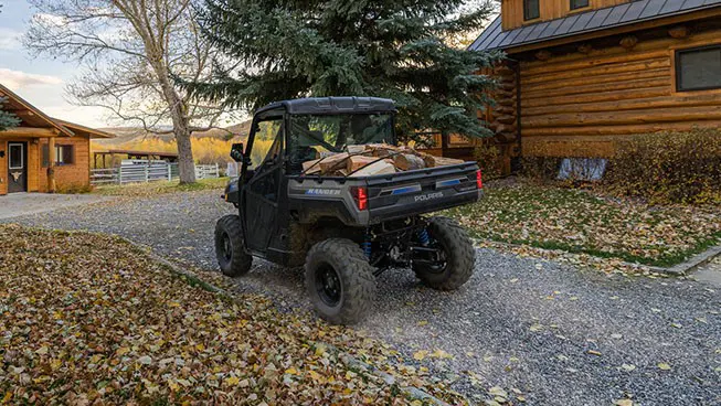 A Polaris RANGER XP Kinetic electric UTV with a cargo box loaded with firewood.