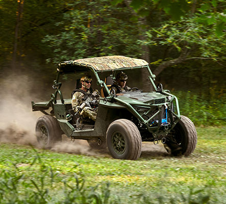 2 soldiers patrolling in a military green polaris mrzr tactical vehicle