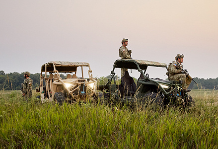 Three soldiers near two MRZR Alpha vehicles