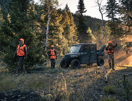 Un groupe de chasseurs dans les bois laissant leur véhicule Ranger