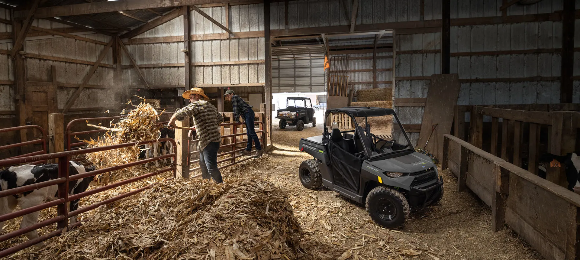 Ranger 150 efi parked inside a barn near two farmers and cows
