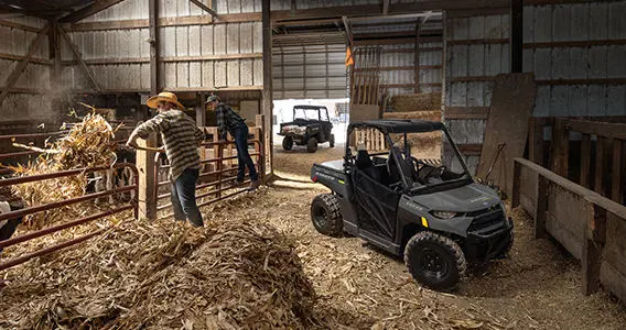 Ranger 150 efi parked inside a barn near two farmers and cows
