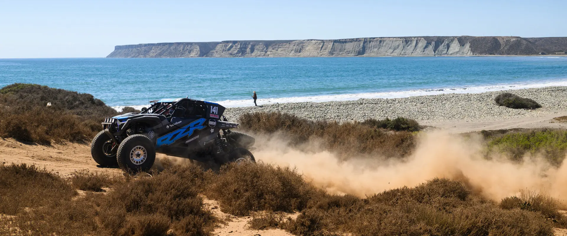 Profil latéral d’un côte à côte Polaris RZR Pro XP 2025 roulant sur un sentier rocailleux.