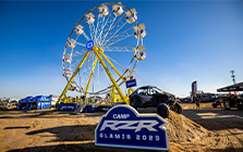 RZR vehicle parked below a RZR Camp promotional banner.