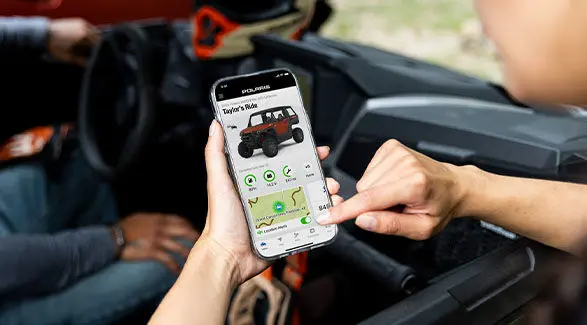 A person using the RIDE COMMAND add to track info on their NorthStar enclosed cab UTV.