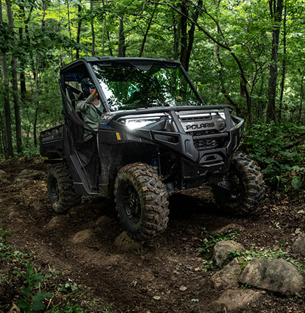 A Polaris RANGER UTV easily navigates a muddy trail on Pro Armor tires.