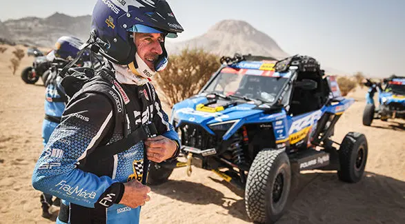 The Dakar Rally Pro driver Xavier de Soultrait, ready for race, with his RZR Pro R Factory in desert.