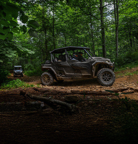 Group of people riding in Polaris GENERAL XP 1000 4-seat UTV on a wooded trail.