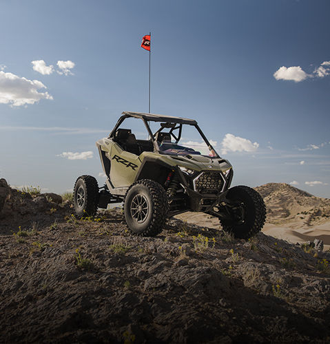 Polaris RZR Pro XP SxS parked on a rocky hill in a desert landscape.