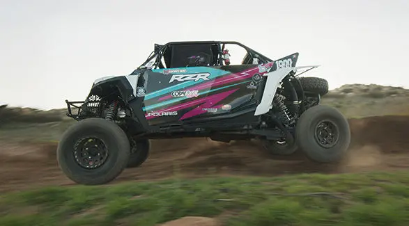 Polaris RZR SxS jumps through the air during off-road race. The vehicle is driven by Fernanda Montiel.