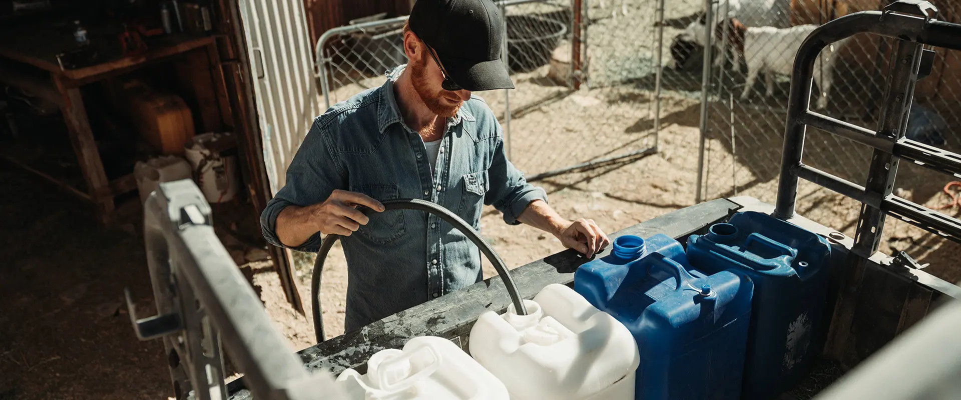Brent Underwood fills blue and white containers in the cargo bed of a Polaris RANGER XP 1000.