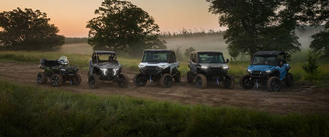 Lineup of Polaris Off-Road Vehicles on a dirty road.
