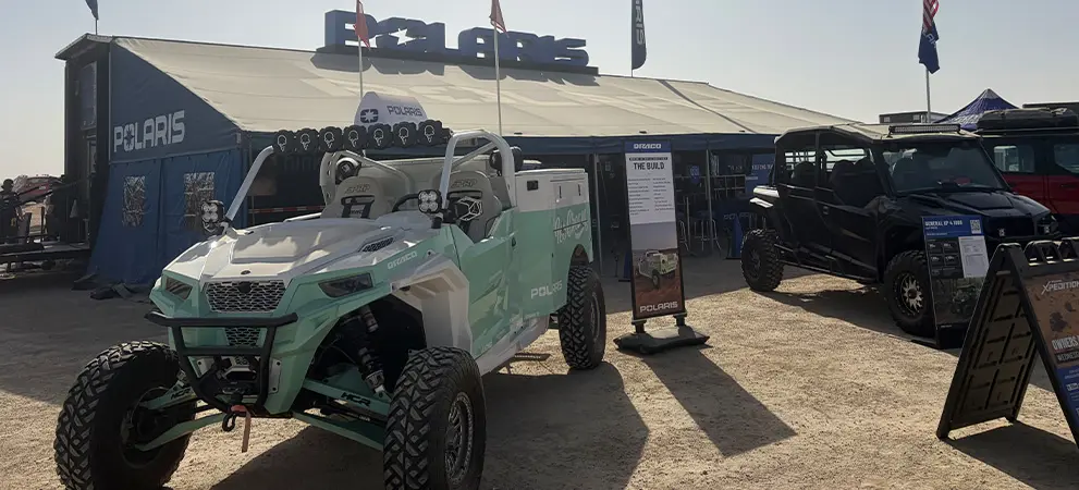 Polaris RZR Side-by-Side displayed outside a Polaris event tent, alongside a Polaris XPEDITION Side-by-Side with signage and product info.