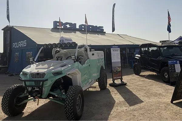 Polaris RZR Side-by-Side displayed outside a Polaris event tent, alongside a Polaris XPEDITION Side-by-Side with signage and product info.