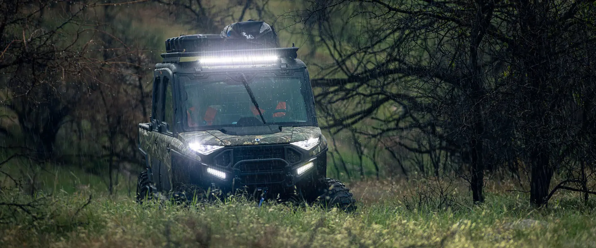 Hunters in a 6-seater enclosed cab UTV driving out to their hunting spots in the rain.