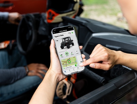 A person using RIDE COMMAND Plus features on the RIDE COMMAND app on their smart phone.