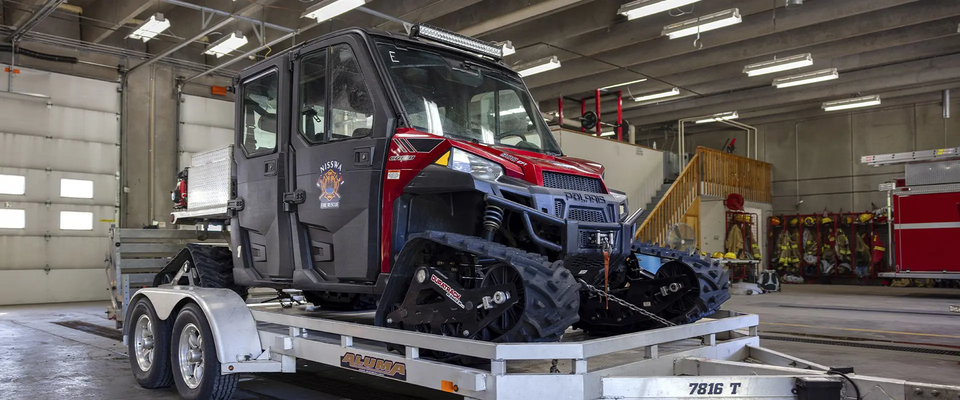Tracked Polaris RANGER fire rescue UTV secured to a trailer inside the Nisswa fire station.