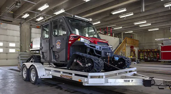 Tracked Polaris RANGER fire rescue UTV secured to a trailer inside the Nisswa fire station.