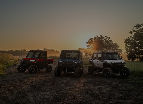 Polaris RANGER UTV, Polaris GENERAL SxS, and Polaris XPEDITION XP Side-by-Side parked on a trail at sunset.