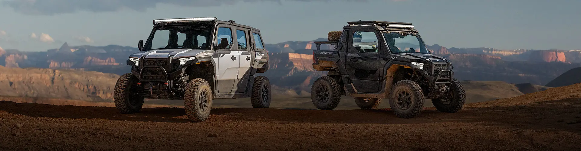 Polaris XPEDITION ADV 5 SxS and Polaris XPEDITION XP SxS parked at a scenic canyon overlook, showcasing adventure-ready off-road capability.