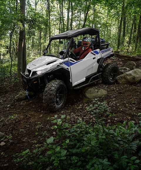 Deux persones à bord d’un VUTT/VCC multisegment circulant dans la forêt.