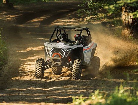 A Polaris RZR side-by-side with a ProStar engine cruising a dusty trail.