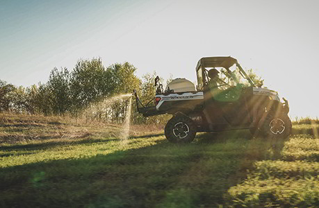 Polaris Ranger spraying water on a greenfield