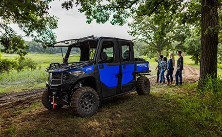 A group of riders standing next to their Ranger Crew SP 570