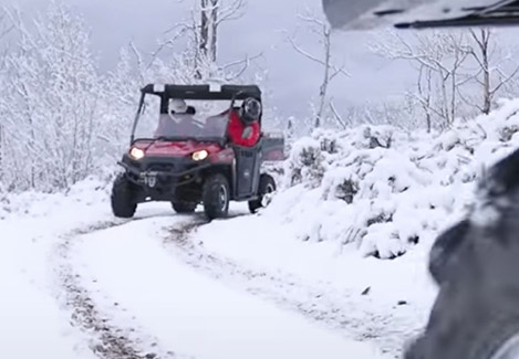 Un véhicule Polaris Ranger qui traverse la neige
