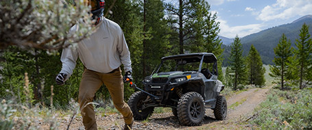 A man using a winch to pull a Polaris Ranger vehicle