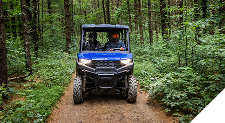 Front view of a Ranger Crew 570 Premium riding on a trail in the forest