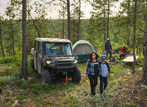 Family hanging out near a parked Ranger Crew
