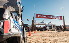 RZR vehicle parked below a Polaris promotional banner