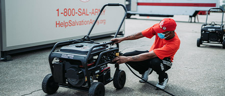 Un homme rechargeant son générateur d’électricité Polaris Power.