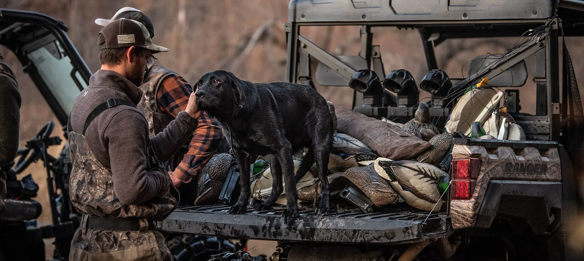 A hunter and his dog on a Ranger vehicle