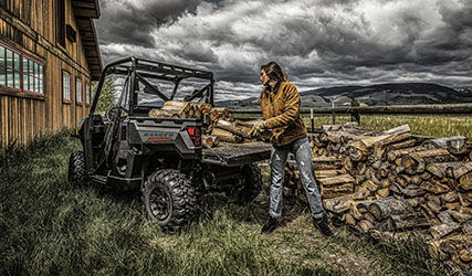 Mujer cargando madera en la caja de carga de su Ranger 1000