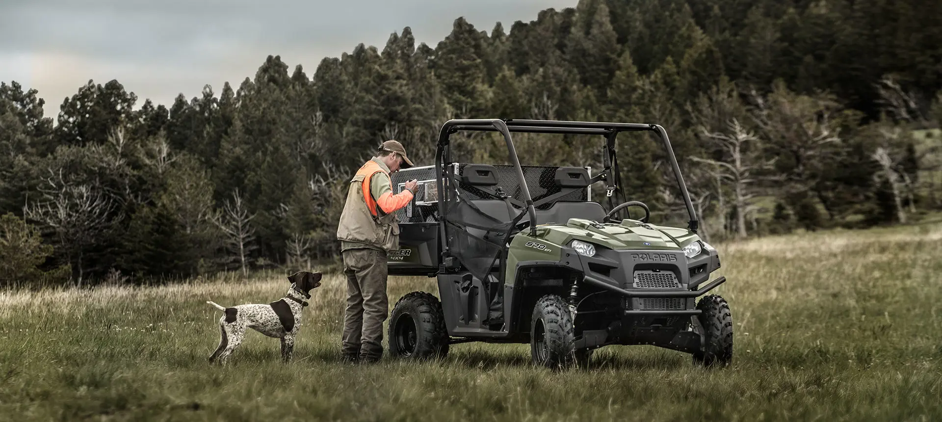 hunter unloading gear from the cargo box on his ranger 570 full-size utv