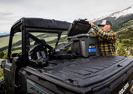 homme déchargeant de l’équipement d’options de rangement Lock & Ride dans le coffre de son ranger crew 1000