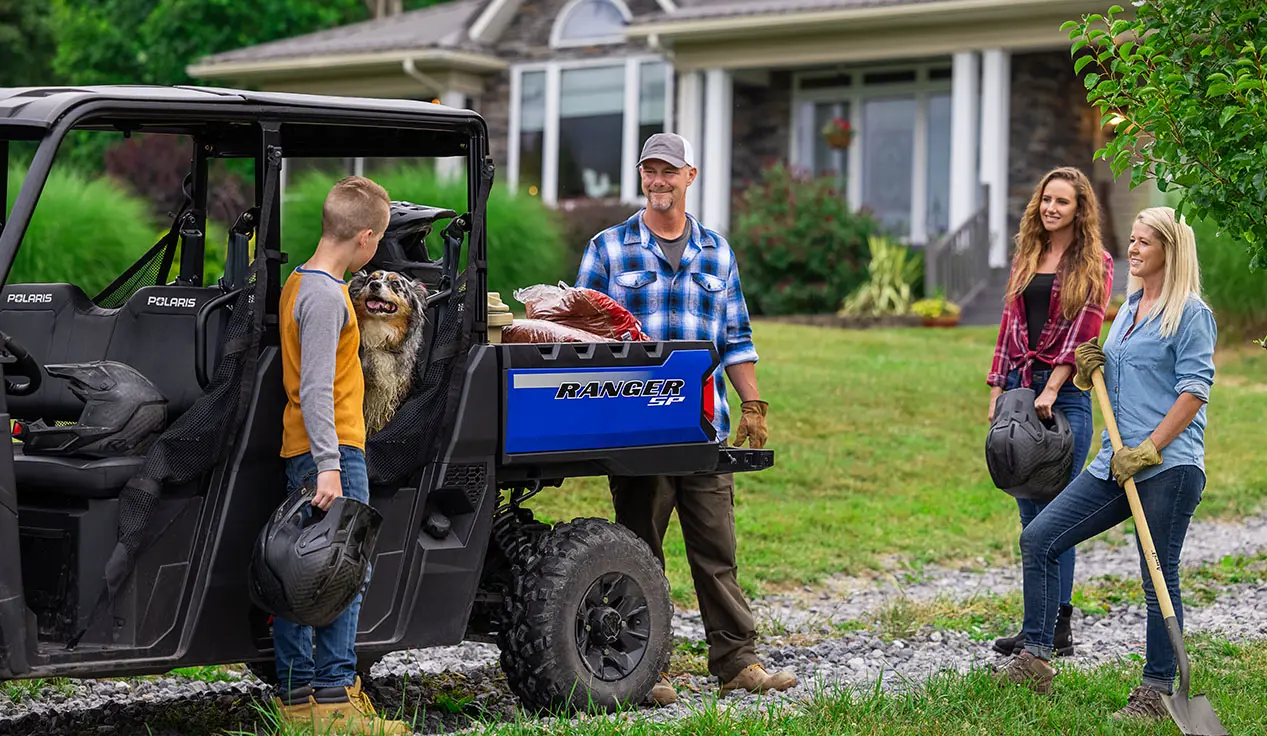 familia que usa su ranger sp 570 para transportar herramientas de jardín