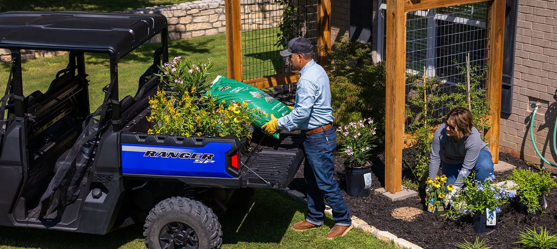 man unloading a bag of soil from the cargo box of his ranger crew sp 570